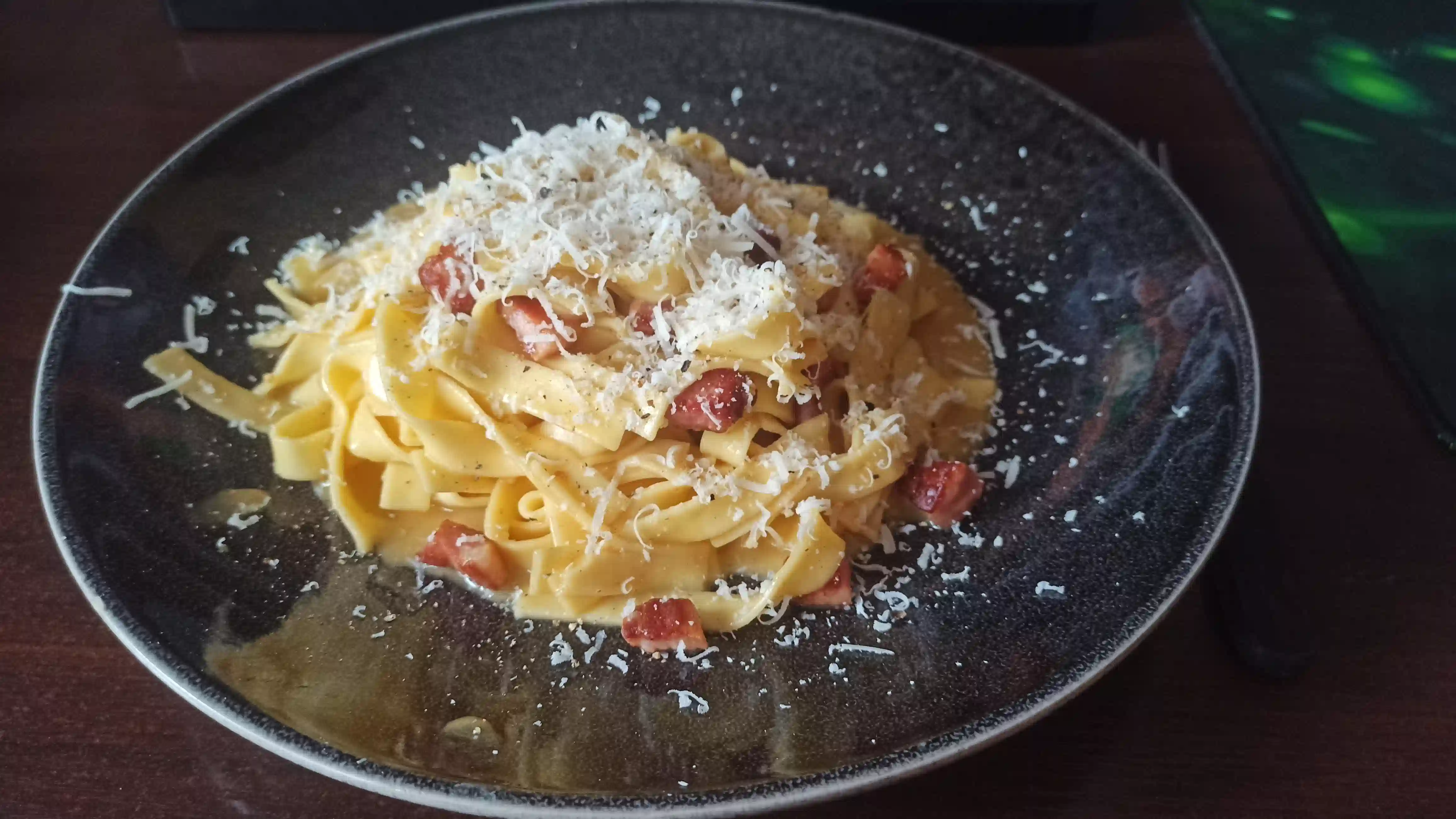 Zdjęcie przedstawia domową carbonarę, pięknie ułożoną na talerzu